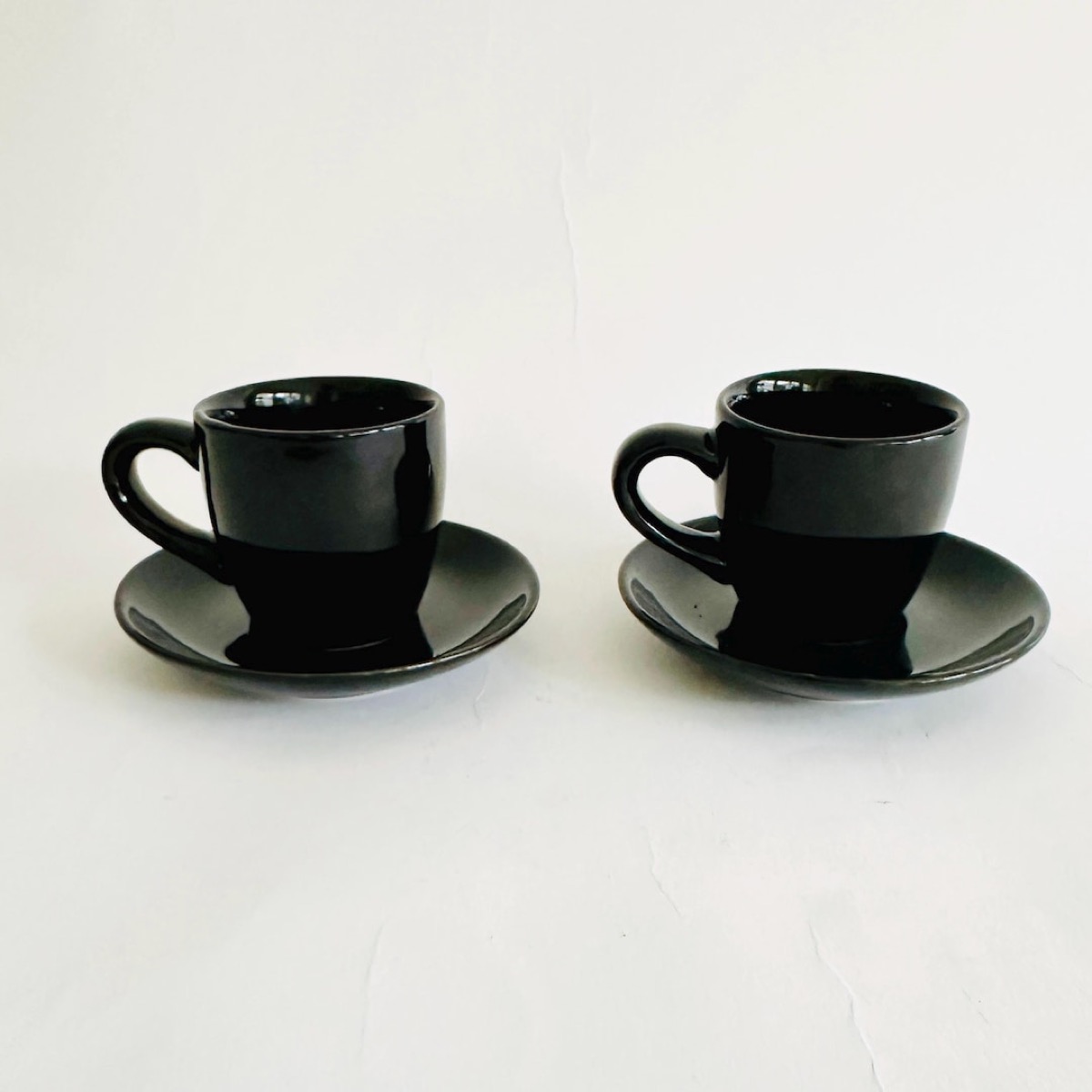Taza de espresso al lado de zapatillas de entrenamiento